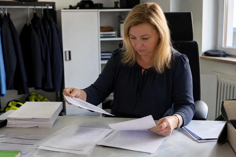 Unterlagen für die Einstellung einer Wachperson liegen geordnet auf einem Schreibtisch